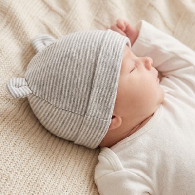 Bonnet bébé Giglio extra-doux, dormant paisiblement dans son berceau.