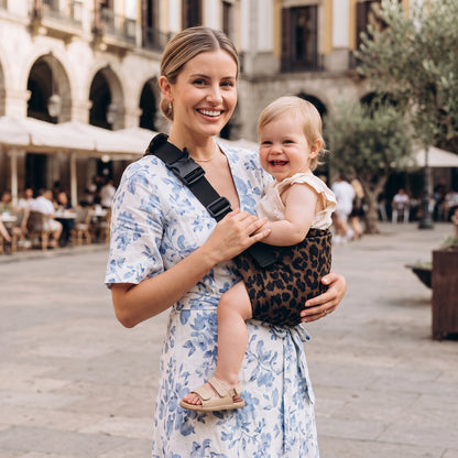 Écharpe de portage Douxora™ — maman et bébé souriants dans les rues de Paris