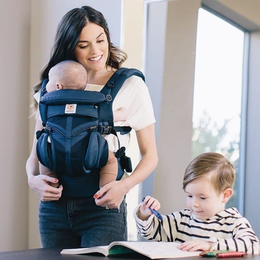 Porte Bébé Ergonomique- Tendressence evolutive Maman garde les mains libres pour son aîné pendant que bébé profite du portage