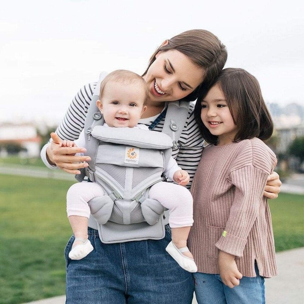 Porte Bébé Deux Coeur Bonheur familial au parc avec le porte-bébé. Confort et ergonomie pour les sorties parents-bébé