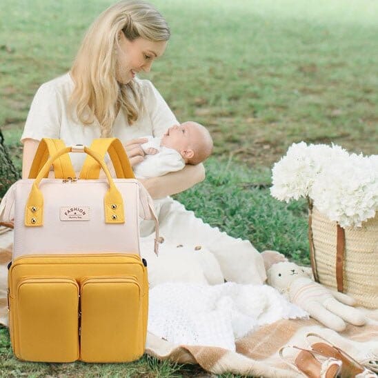 Sac a Langer Bebe NomaChic jaune et blanc polyvalent avec bébé au parc