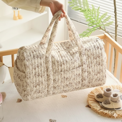Sac à Langer Grand maman déposé dans le lit de bébé. Idéal pour tout transporter.